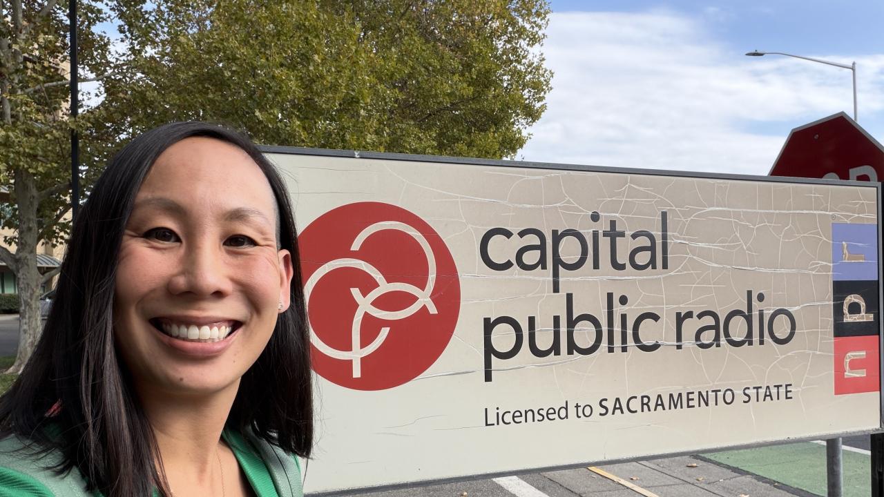 Dr. Lauren Au standing near the Capital Public Radio Sign