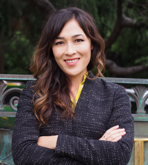 Jennifer Falbe, profile photo in black jacket with arms crossed, smiling