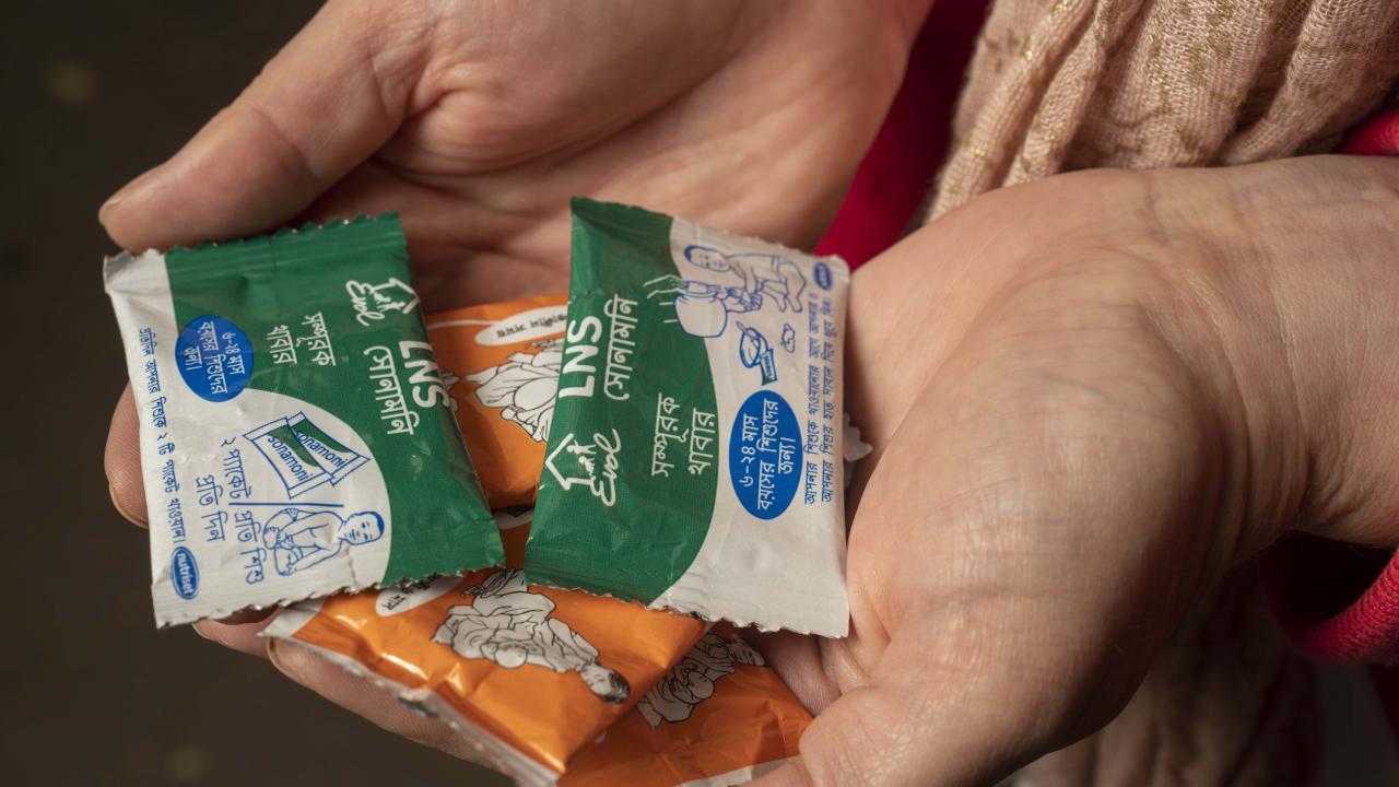 Christine Stewart's hands holding sachet packets of Lipid Nutrient Supplements