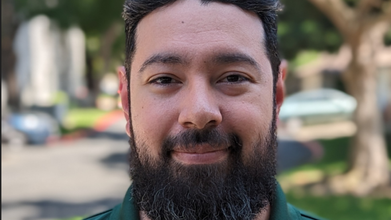 Jonn Fajardo headshot in green shirt outside
