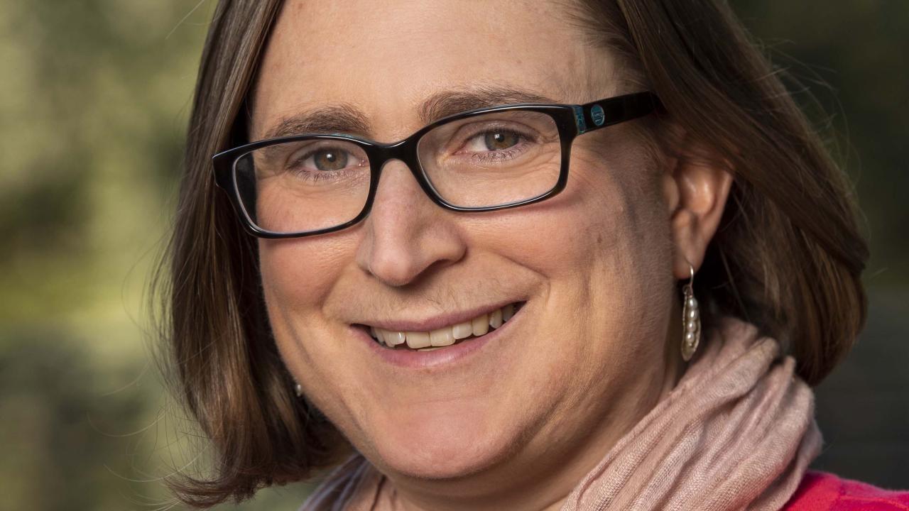 Close up profile photo of Christine Stewart's face with glasses