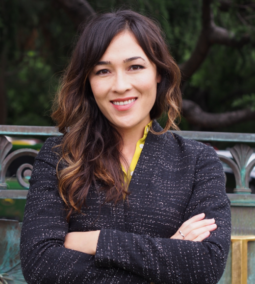 Jennifer Falbe, profile photo in black jacket with arms crossed, smiling