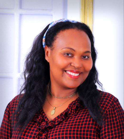 Debritu headshot, w/ hair in headband scarf & red-black checked shirt