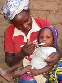 African woman feeding baby on her lap-LNS Ghana .jpg