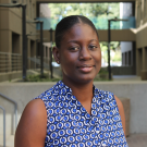 Sika standing in Meyer Hall breezeway, in blue & white circles sleeveless top